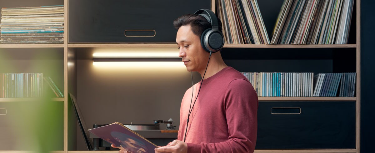 En mann som lytter til musikk med Philips X3-hodetelefoner