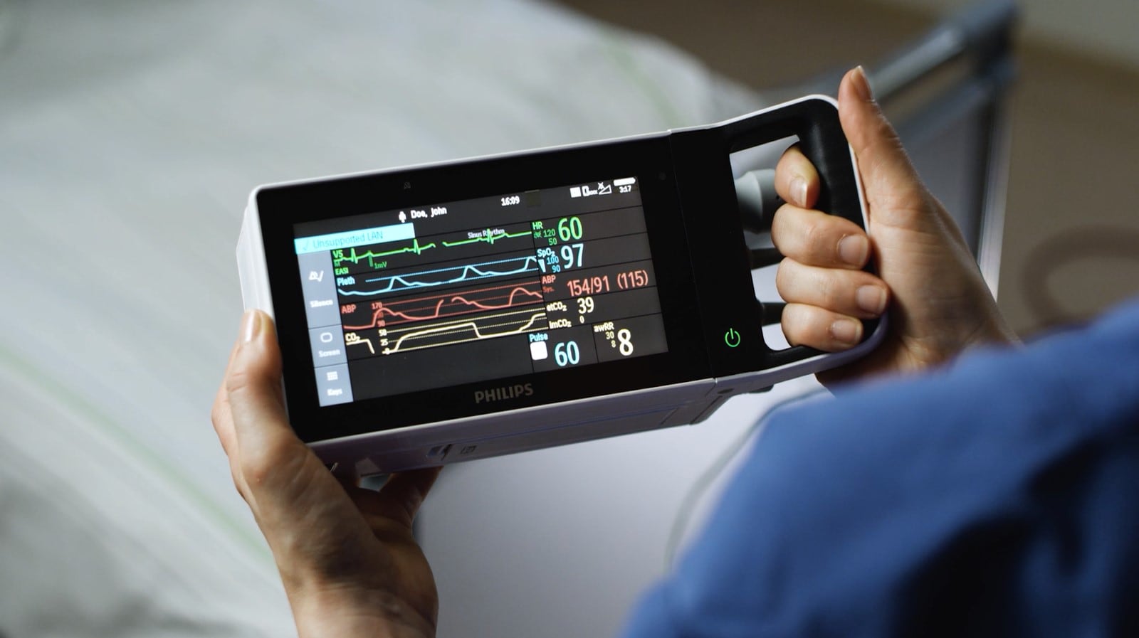 a person holding a mobile patient monitoring device