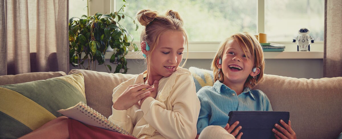 Barn som liker en video med Philips-barnehodetelefoner med åpent øre