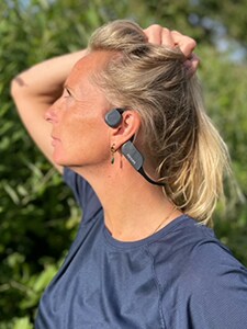 Kvinne med Philips Bluetooth-hodetelefoner med benledning