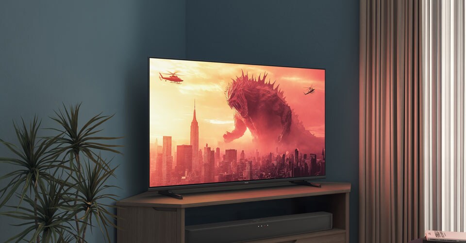 En Philips-TV på et hjørnestativ viser en Godzilla-film