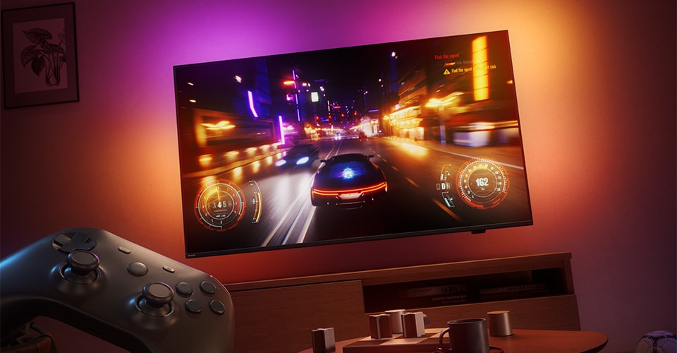 Et racingspill vises på en Philips Ambilight-TV i et svakt opplyst rom