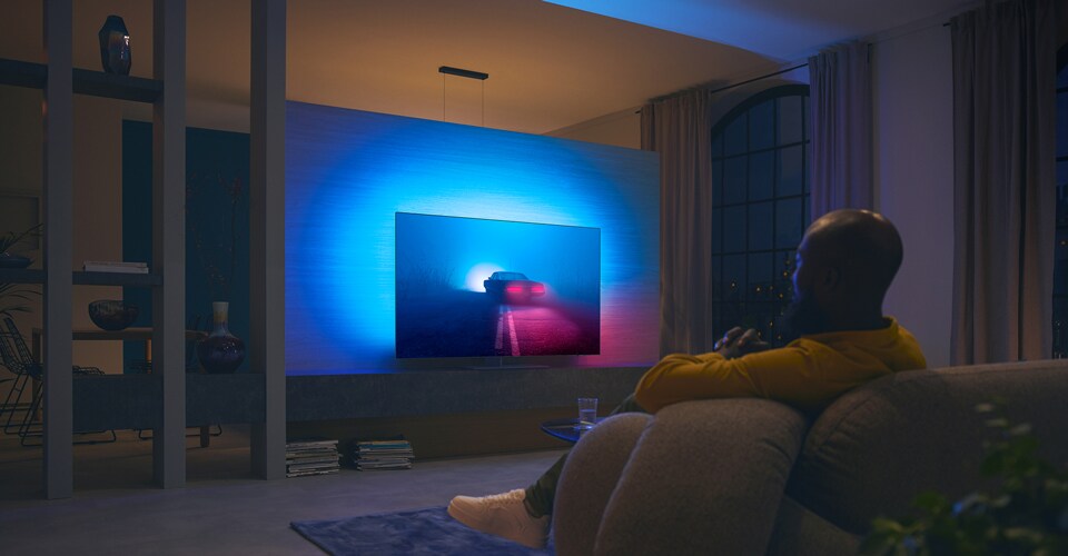 A couple is watching film on Ambilight TV