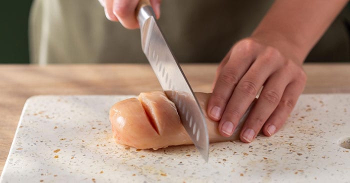 Bruk en skarp kniv til å skjære 4–5 snitt på tvers av kyllingbrystene, avhengig av størrelsen.