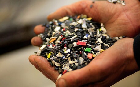 Et nærbilde av hender som holder rundt ødelagte stykker materiale.